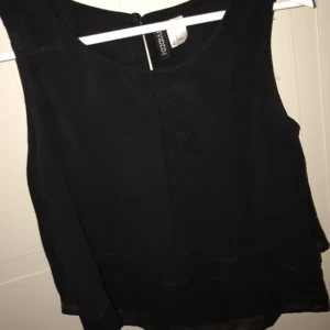  - Svart blus med lite volanger