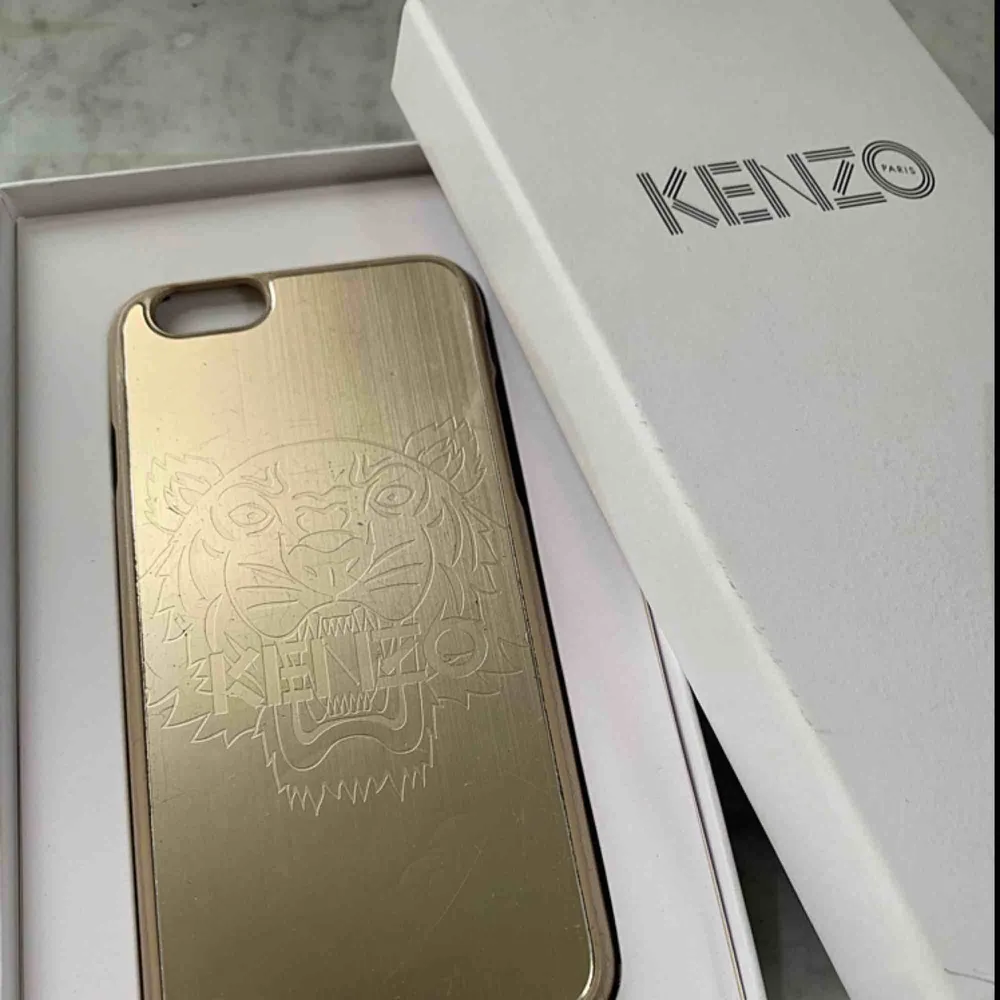 Ett kenzo-skal i guld med en inristad tiger. Passar iPhone 6. . Accessoarer.