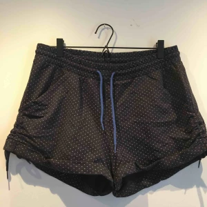  - Adidas shorts i mjukt material. Dragsko i midjan och på sidorna. 