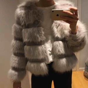  - Pälsjacka från Vera & Lucy. Grå/lila fuskpäls i storlek S. Endast använd 2 gånger så mycket bra skick, men översta knappen har gått sönder men funkar ändå att knäppa jackan. Möts upp i Stockholm!