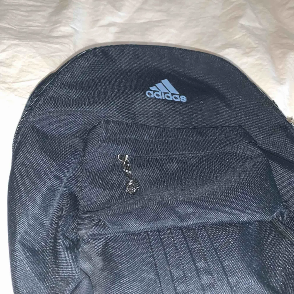Mini Adidas ryggsäck i mörkblått. Har endast använts några gånger och är i fint skick. Köpt på Adidas i Sthlm för 249kr. Frakten kostar 30kr och ingår inte i priset. . Väskor.