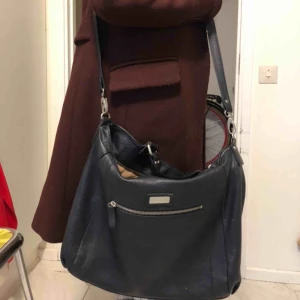 Marc O’Polo väska  - FLYTTAR SÅ VILL GÄRNA BLI AV MED DEN. B35xH32xD16 cm Marc O’Polo väska i marinblått skinn. En ytterficka med dragkedja och 5 innerfickor (varav två med dragkedja) utöver det stora huvudfacket. Avtagbar axelrem och vanliga handtag. Jättefint skick. Nypris var 2000. 