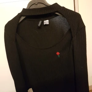 Topp - Topp som är ur snygg med en ros påsydd, storlek M och passar L