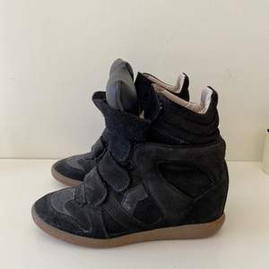 Säljer mina svarta Isabel Marant high-top wedge sneakers i storlek 39. Använda men i bra skick. Det slitage som finns är på sulan (se bild). Köpte dem helt nya från MyTheresa 2017 (nypris ca 4200kr). Man får med dustbags till båda skorna samt boxen.