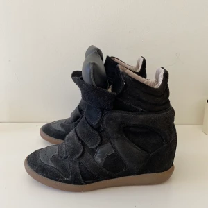 Isabel Marant Beckett - Säljer mina svarta Isabel Marant high-top wedge sneakers i storlek 39. Använda men i bra skick. Det slitage som finns är på sulan (se bild). Köpte dem helt nya från MyTheresa 2017 (nypris ca 4200kr). Man får med dustbags till båda skorna samt boxen.