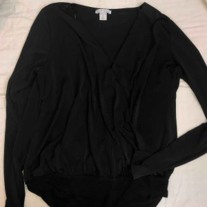  - Säljer denna svarta omlottbody i storlek S. Fint skick. Frakt tillkommer på 59kr🦋