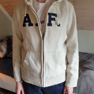 Abercrombie and fitch hoodie  - Abercrombie and fitch hoodie med dragkedja. Storlek S I herrstorlek. Slitningar på hoodie (de ska vara där). Knappt använd. Passar både tjejer och killar. Går att använda som "jacka" nu i sommar då den är ganska tjock. Frakt tillkommer.