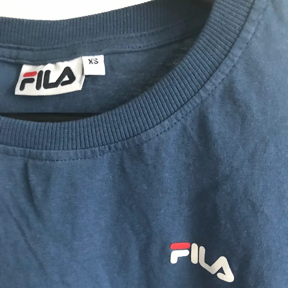 Blå Fila t-shirt som köptes för cirka 300kr säljes nu för 70kr. Fortfarande i bra skick knappt använd. Priset kan diskuteras och köparen står för frakten💕. T-shirts.