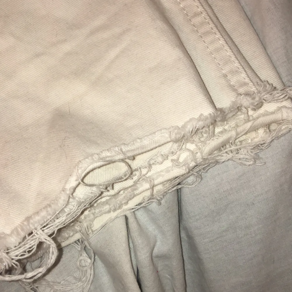 Ett par vita byxor med silvriga knappar. Slitningar längst ner på byxorna, sitter tajt vid höften men blir mer straight längre ner :) har använt typ 3 gånger . Jeans & Byxor.