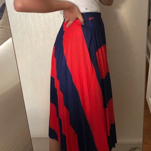 Bershka kjol - En röd och blå randig, plisserad kjol från bershka! Endast använd en gång. Köpt i spanien men kommer inte till användning