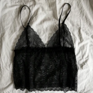 Svart spetslinne strl M - Jättefin svart spetstopp i strl M. Den är i mycket bra skick, knappt använd. Den har resårband så är stretching och bekväm ✨