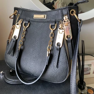 River Island väska  - Fin väska från River Island. Bra skick nypris 500kr. 3 fack med både korta och långt band. 