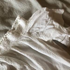 Fin vit blus med detaljer på ärmarna, offshoulder, använt en gång