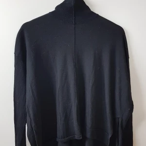 Acne - svart polotröja "Zola" - Tunn polotröja i lite asymmetrisk skärning. Från Acne höst/vinterkollektion 2011. 100% ull. Lite använd, bra skick.