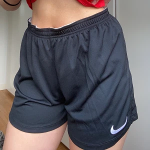 Nike fotbollsshorts stl M - Luftiga träningsshorts som passar perfekt till gym, fotboll eller annan träning. Aldrig använda då jag ångrade mig när jag inte längre kunde lämna tillbaka. 