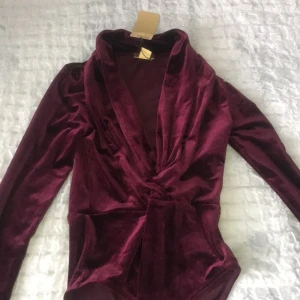 Velvet Body - •En body i velvet från H&M, med knappar i skrevet. •Oanvänd. Frakt ingår!