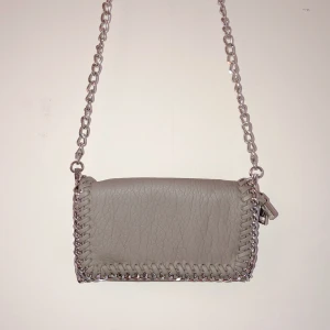 Beige axelväska - Oanvänd beige cool axelväska från Tiamo, köptes på Accent för ca 250 kronor. Jag säljer för 70 kr! Köparen står för frakt💖