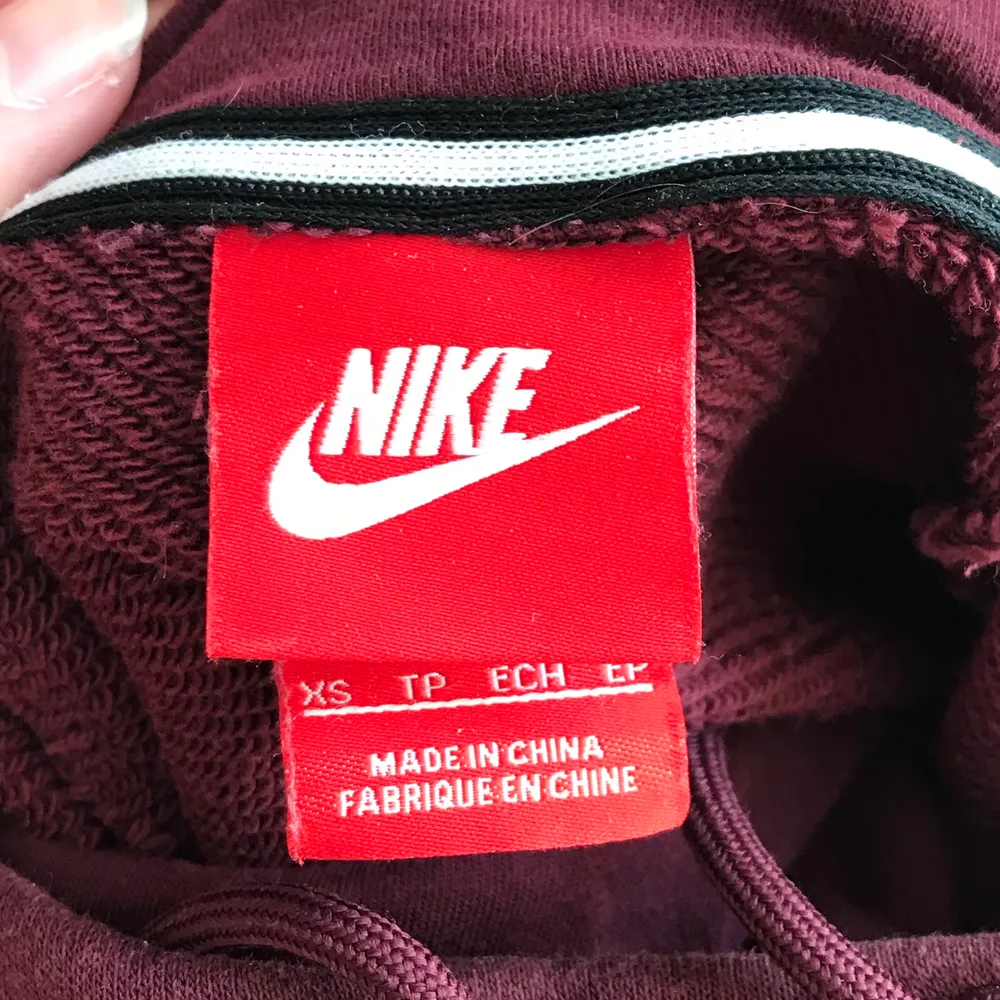 Vinröd hoodie med krage från Nike. Texten är fluffig och vit. Använd ett fåtal gånger och är i mycket bra skick! . Hoodies.