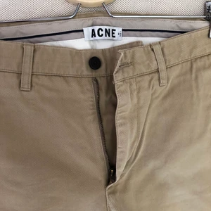 ACNE Chinos stl 48 - Beige chinos från ACNE i stl 48. Använda ett fåtal gånger och därför ett mycket bra skick. Nypris ca 2000kr.