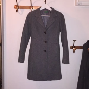  - Grå kappa från Benetton, kan knäppas på olika sätt. Använd fåtal gånger. Snygg passform 