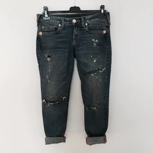  - Slitna jeans från True Religion i modellen Stella. 

Smala i modellen och lågt skurna. Har den klassiska "jeans blåa" färgen. 