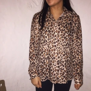  - Leopadskjorta i glansigt tyg, är lagad under ena armen! 
Betalning sker helst via swish. Köparen betalar frakten.