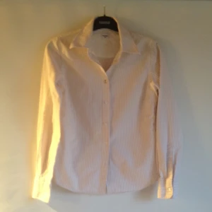  - En mycket styltig boomerang Stockholm skjorta slim fit, randig beige och vit. Fina detaljer perfekt skick och kvalité.  Jag har storlek 34/36 och den passar perfekt. 