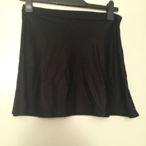  - Svart minikjol/högmidja. Elastisk material. 