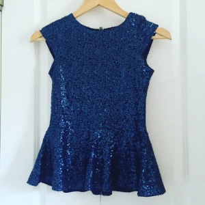  - Glittrig peplum topp