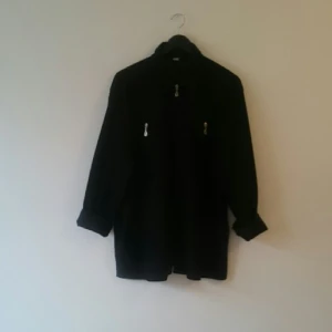  - Svart tunn jacka med fina detaljer, köpt second hand utan lappar. Större storlek/oversize