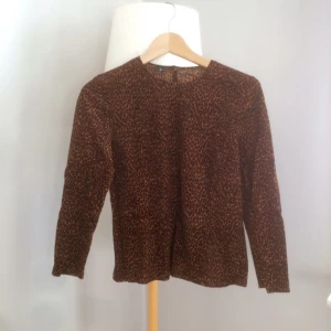  - Leopardmönstrad tröja i kortare modell. Lite plysch-aktigt tyg, men absolut inte glansigt. Hög u-ringning. 