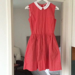  - Sommardröm! Röd klänning med vita prickar och vit krage. Resår i midjan och dragkedja bak. Tyllkjol under för extra volym på kjolen. Från popboutique i Göteborg. Den har bara blivit hängandes, men förtjänar så att bli buren!