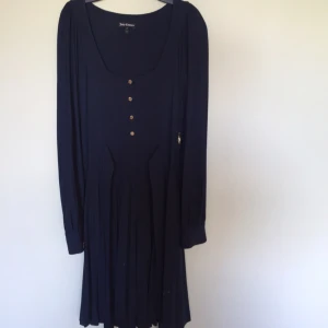  - Marinblå klänning i mjukt fallande tyg, band att knyta i midjan 