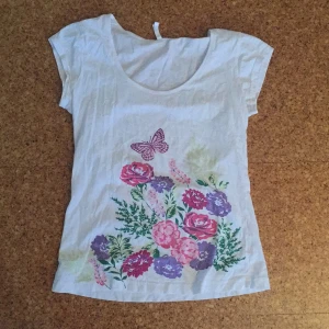  - T-shirt med blommor.