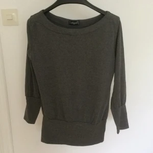  - Grå tröja. Fint skick, inga noppor. Tajt över höften, lösare kring midjan. Tar swish, köparen står för frakten. 