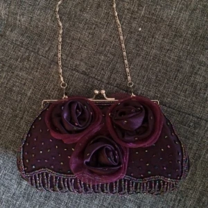  - Superfin aftonväska med blommor och pärlor. Kort kedja sitter nu och en längre medföljer. Aldrig använd, bara hängt i gadderoben. 