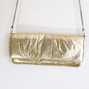  - Liten chik guldväska från Åhléns. Avtagbar kedja så den kan även användas som kuvertväska. 

På baksidan har de nötts bort lite av guldfärgen. Där av det billiga priset. Se bild 3.

Fraktas för 49kr 
Betalning sker via svisch ✨✨✨✨