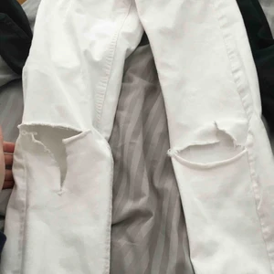  - Tighta, vita, jeans med hål på knäna. Även klippta nere vid anklarna. Köparen står för frakt