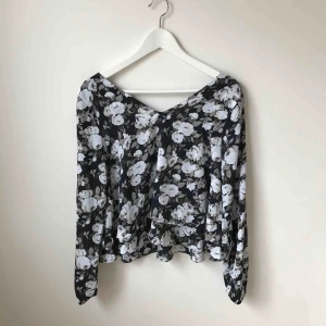  - Svart, vit och grå blommig blus med volanger i nyskick. Använd 2 gånger.  Köparen står för fraktkostnad enligt postens portotabell.