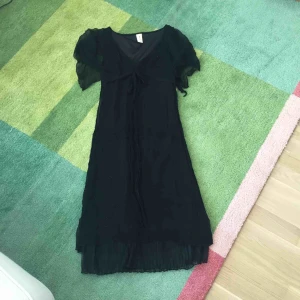  - Vacker svart klänning från danska Isabell Kristensen. Fina pärldetaljer och vackert skirt material.