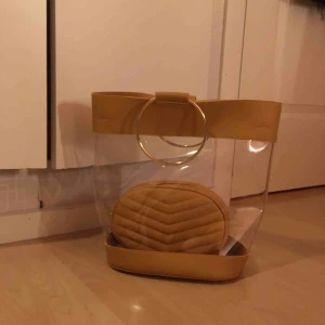  - Cool genomskinlig vinylväska med senapsgula och guldiga detaljer❣️ Väskan inuti tillhör ett bälte och kan köpad till för 40kr. Köpt på boohoo för ett tag sedan nu men har inte blivit använd mer än 10 gånger, frakt tillkommer!