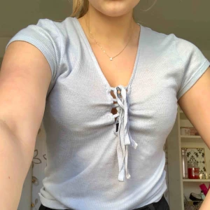  - Ljusblå t-shirt med snörning i fram. Köpare står för frakt ☺️