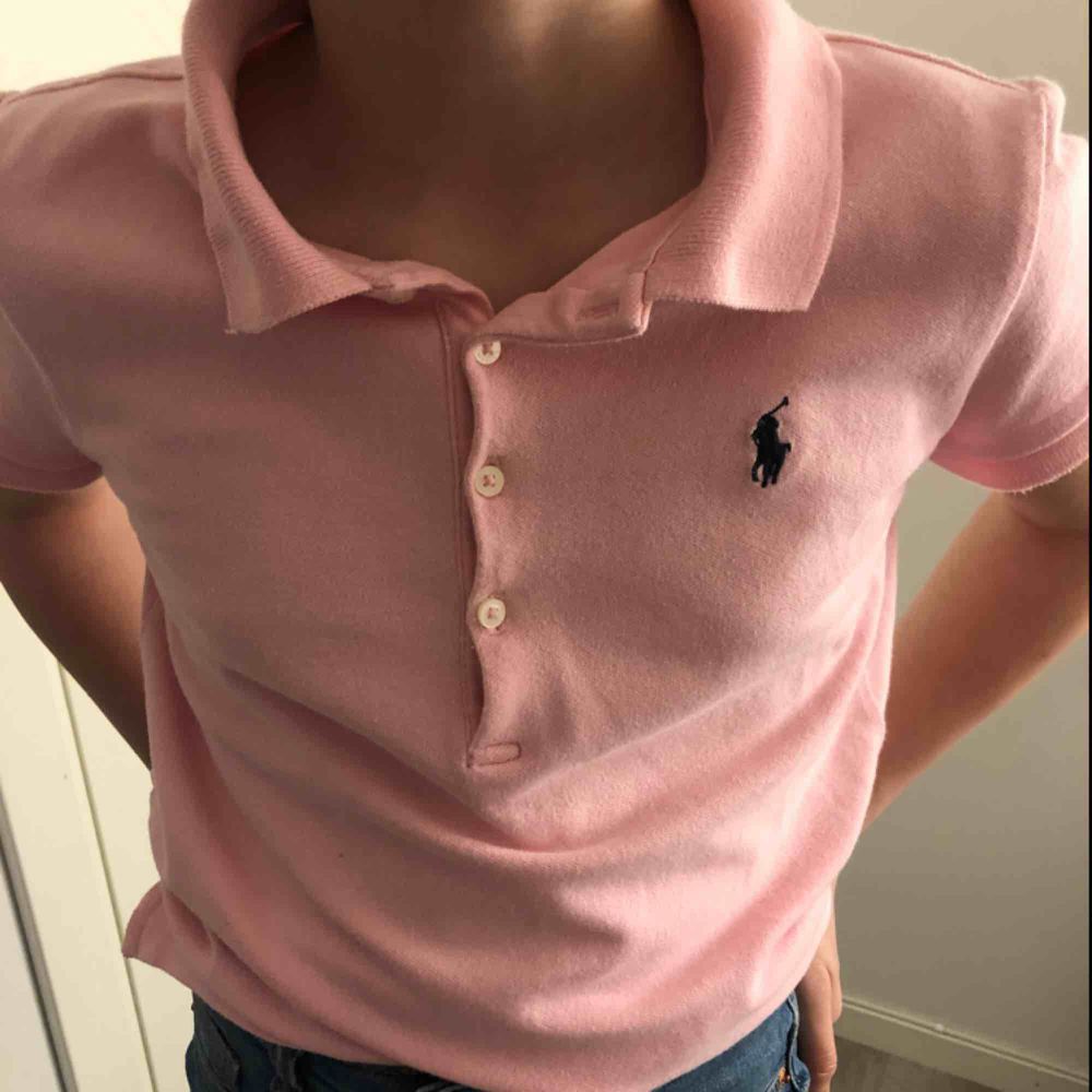 Polo Ralph Lauren tröja med polokrage. Beskrivs för 12-14 år, men passar även yngre åldrar. Tröjan är i fint skick utan fläckar och passar perfekt både till skolan eller vid finare tillfällen.. T-shirts.