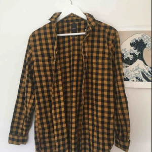 - Rutig skjorta i färgerna svart och gul. Jag har aldrig använt den och den är i bra skick. Är snygg att ha både som  en traditionell skjorta och som ”jacka” att slänga på sig. Hör av dig vid eventuella frågor om pris eller plagg!
