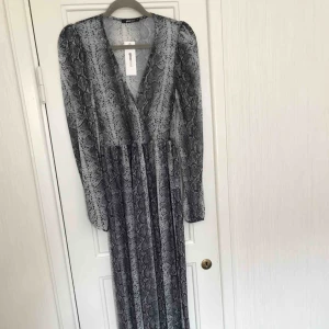  - Helt NY långklänning i ormmönster, aldrig använd.  Perfekt inför sommarens fester, bröllop, student etc.  Nypris : 449:- 