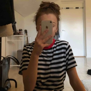  - Superfin och skön svart randig t-shirt med röd liten krage från bikbok. Storlek L och slutar på mitten av rumpan. Endast använd ett par gånger och därav i väldigt fint skick! Eventuell frakt tillkommer.