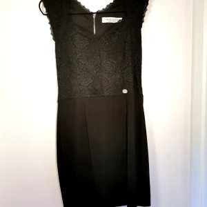 Svart klänning  - Väldigt fin svart klänning i nyskick. Kjolen är följsam och stretchig. Överdelen är i spets. 