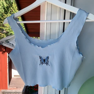 Blått linne med fjärilstryck - Blått croppat linne från SHEIN med fjärilstryck på. Jätte skön kvalitet,säljer om jag får tillräckligt högt bud. Storlek S men kan passa på XS-M. Högsta bud 115kr inklusive frakt✨ Förpackningspåse går att få med om man vill.