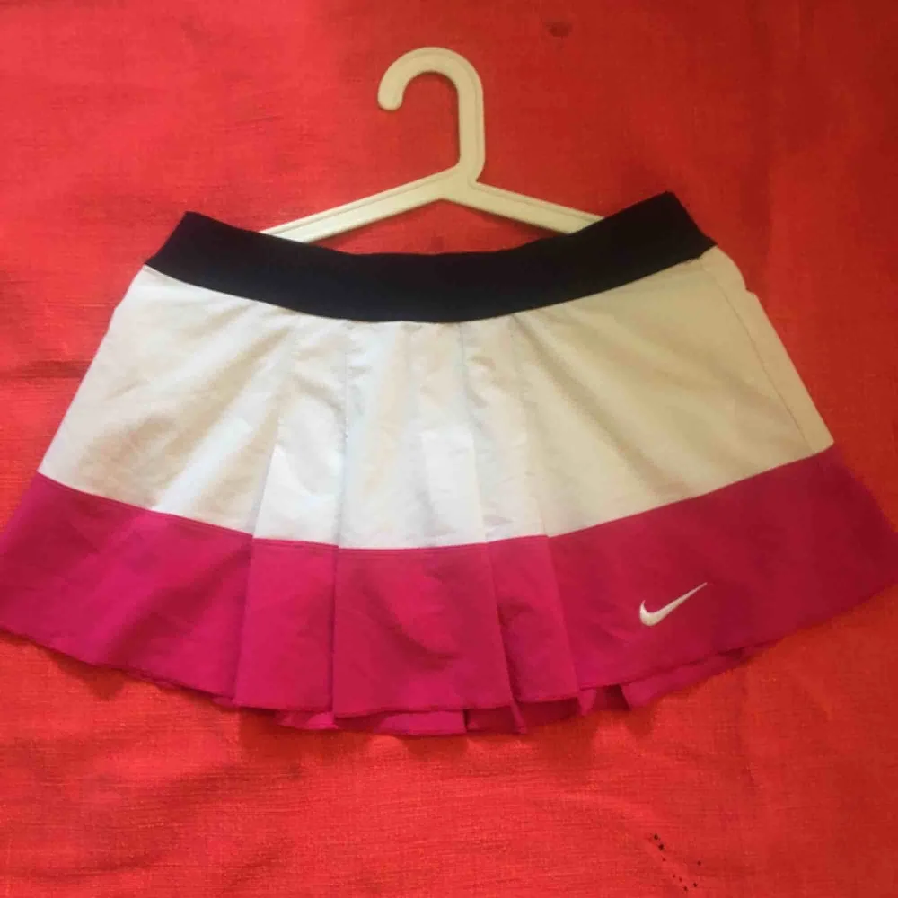 Superfin tenniskjol i tre färger ( rosa, blå, vit) från Nike. Den är ganska kort ( som tenniskjolar är) men har innerbyxor som täcker bra och inte syns igenom. Säljer dem för att de tyvärr har blivit lite för små på mig. Skulle säga att den passar S-M. . Kjolar.