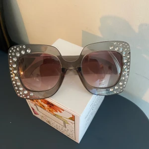 Coola grå solglasögon - Coola, stora och  grå solglasögon med ”diamant”detaljer! Fint skick. Säljer pga inte min stil. Köparen står för frakt. Kan mötas i Lund. 